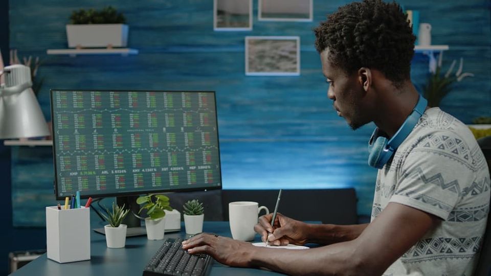 mann sitzt am pc und studiert aktienkurse